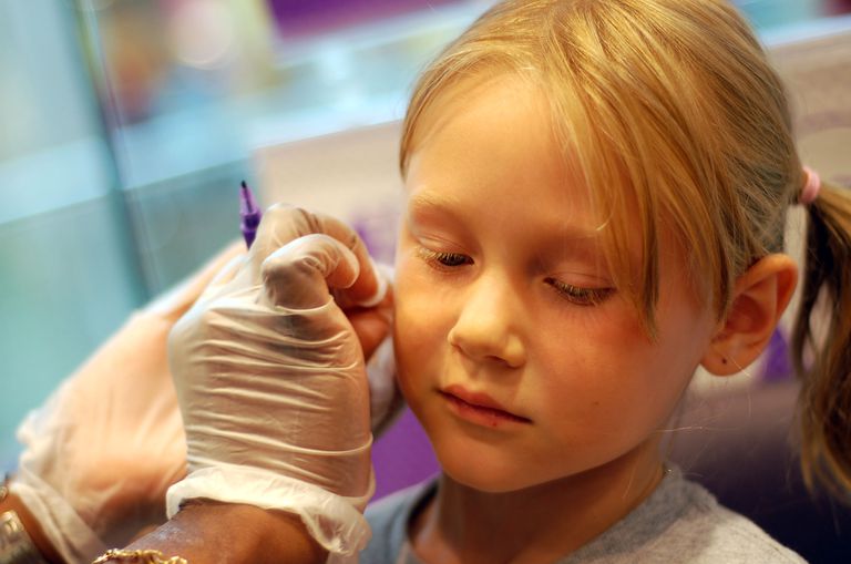 little girl getting her ear pierced