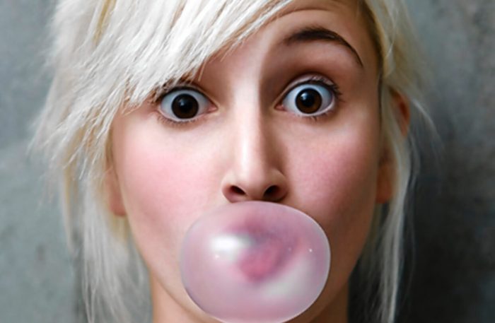 girl chewing gum and blowing a bubble