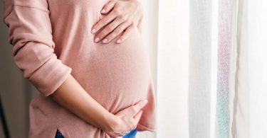 pregnant woman with hands on stomach