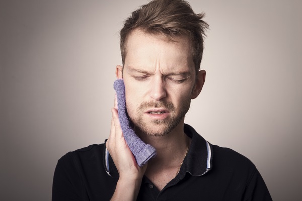 man holding a towel to his jaw